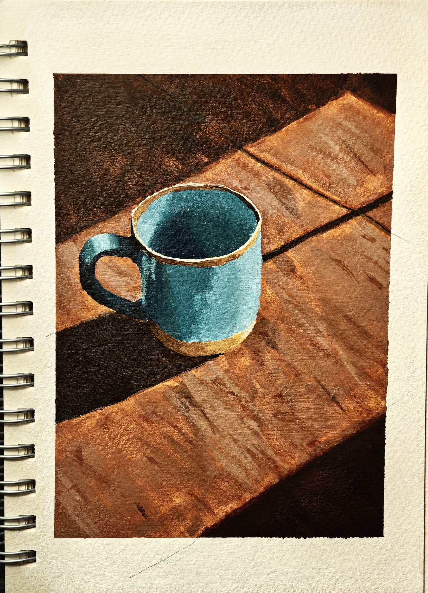Acrylic study of a teal enamel mug on a wooden table, a band of sunlight across the wood and deep shadow behind, painted in a masked-off sketchbook page