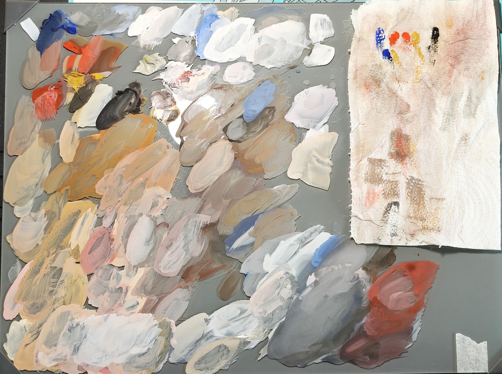 The mixing palette after both studies: dozens of overlapping mixes of skin tones, greys and blues spread across a grey palette, with a paper towel of test dabs