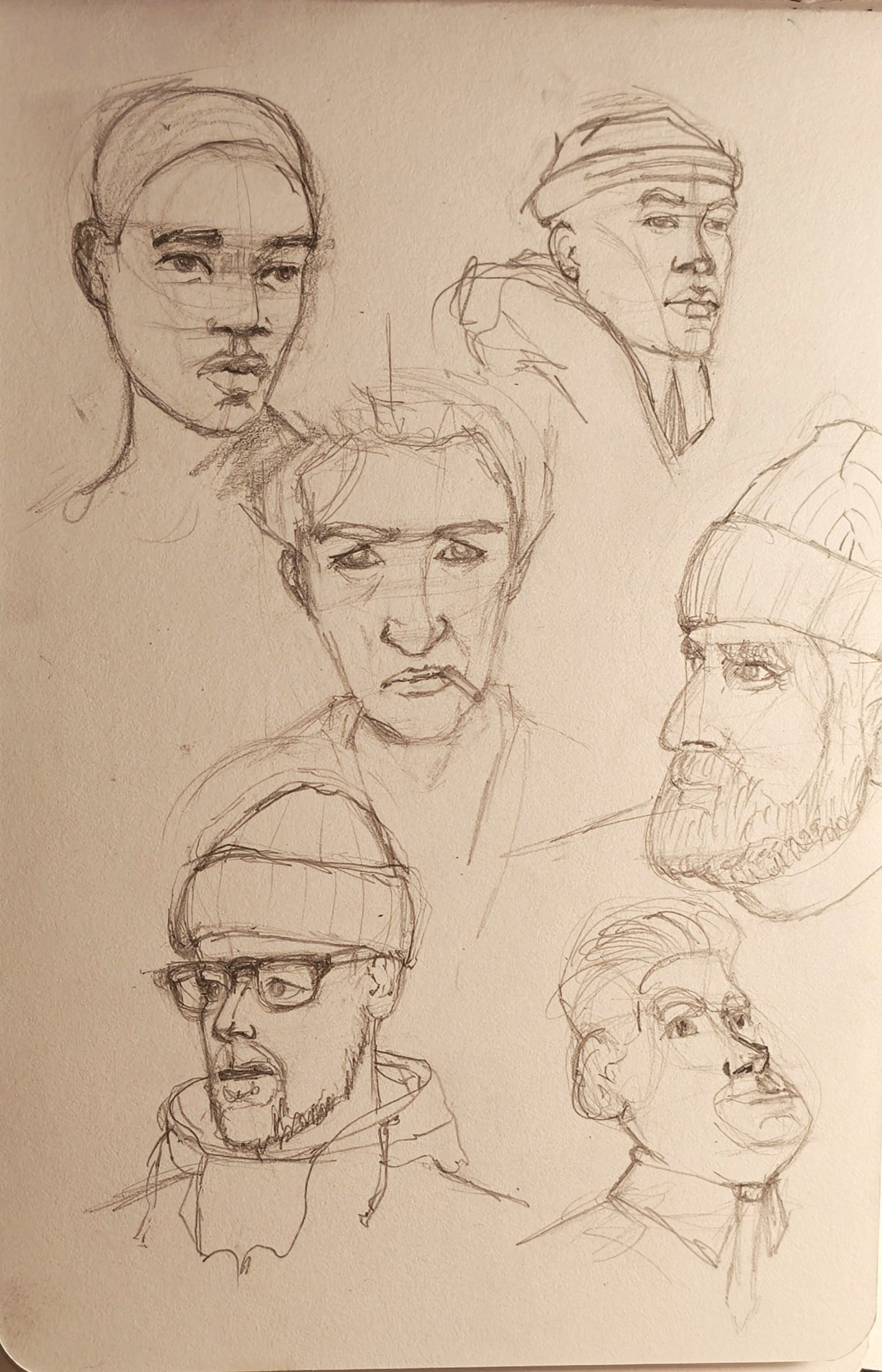 Sketchbook page of quick pencil heads at different angles, construction shapes left visible under the lines